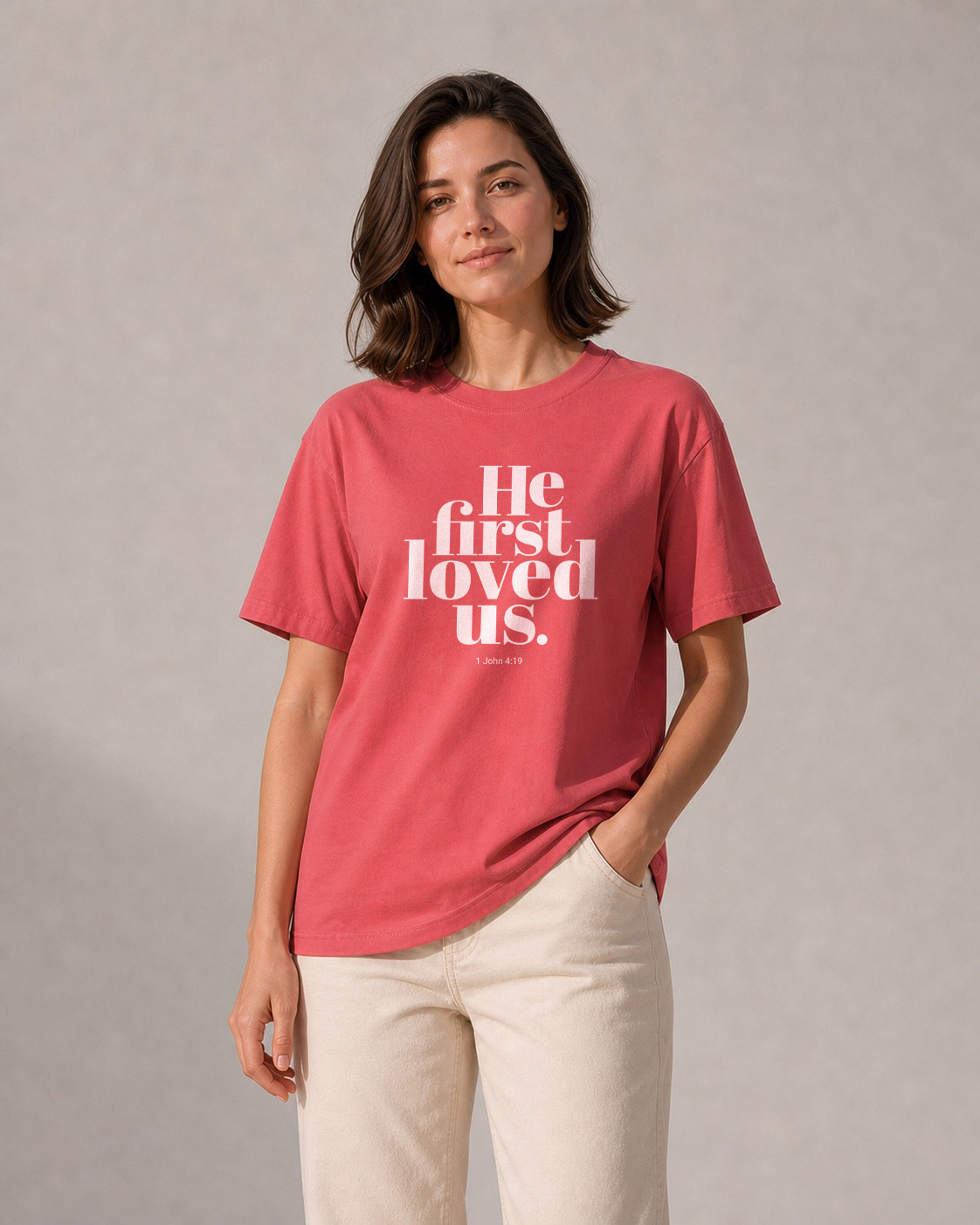 Model wearing the He First Loved Us T‑Shirt